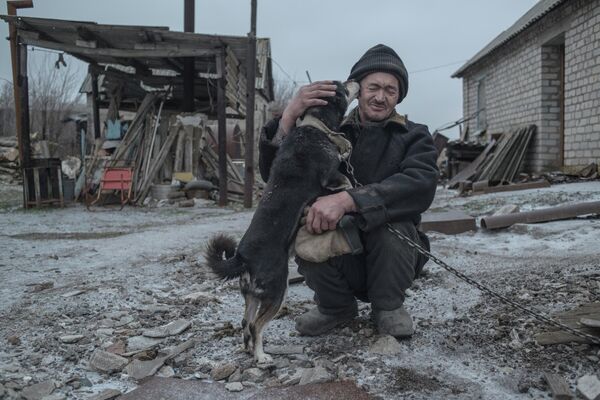 62 gadus vecais Aleksandrs Vasiļjevs un viņa suns ir vieni no pēdejiem Novomarjevkas iedzīvotājiem. Šo fotogrāfiju Valērijs Meļņikovs iekļāva sērijā &quot;Pelēkā zona&quot;, kas izcīnīja Grand Prix fotokonkursā Intarget Photolux Award-2019 - Sputnik Latvija