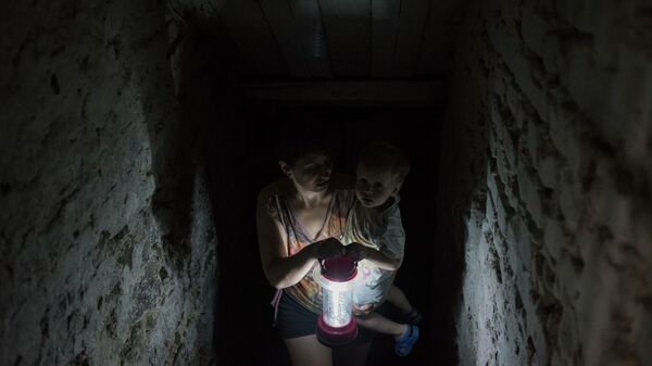 Женщина с ребенком прячется в подвале своего дома в Горловке, 30 июня 2016 года  - Sputnik Латвия