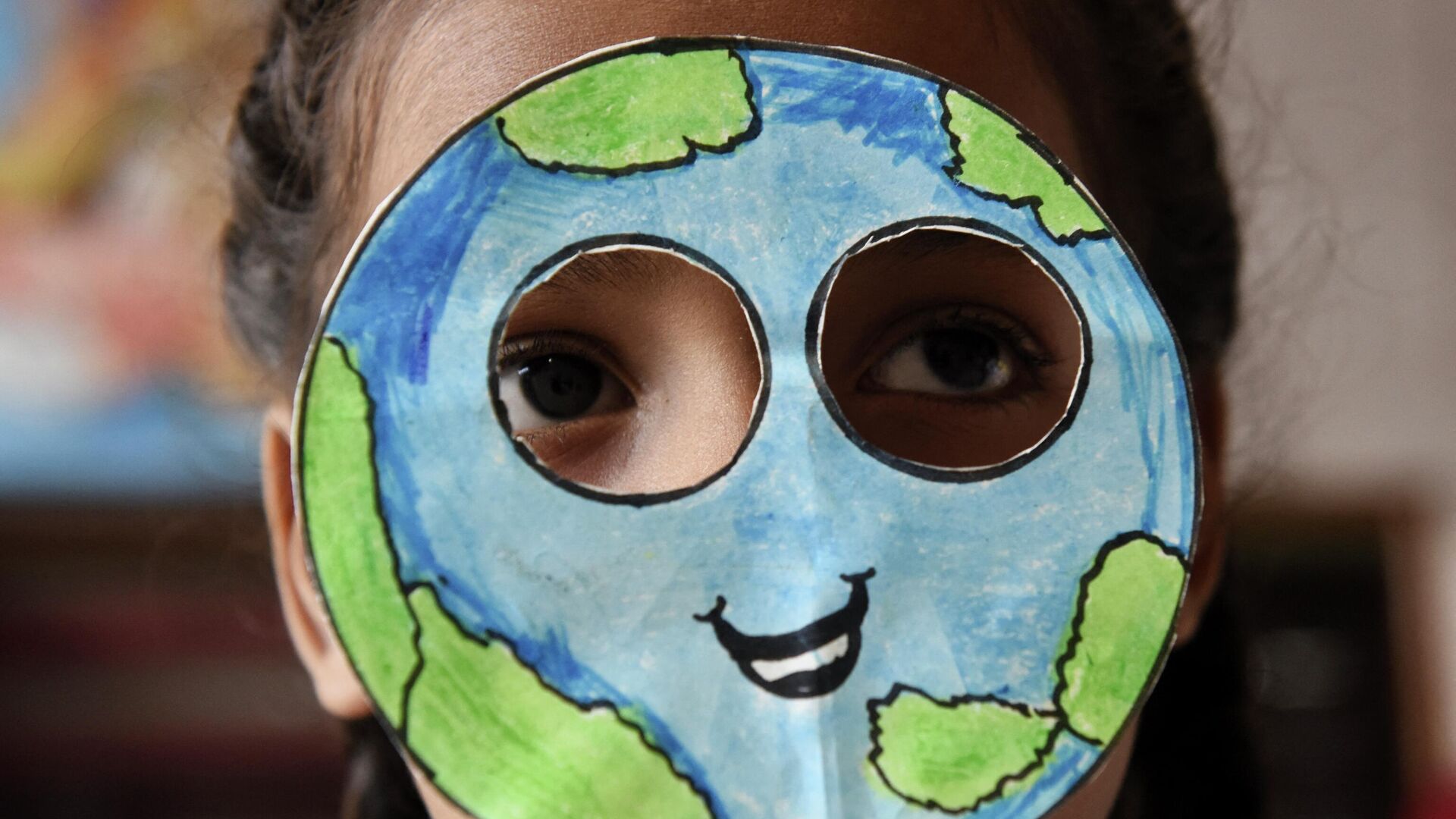 Ученик надевает маску, сделанную в форме планеты Земля, во время мероприятия по случаю Дня Земли в школе в Амритсаре, Индия - Sputnik Латвия, 1920, 03.08.2022