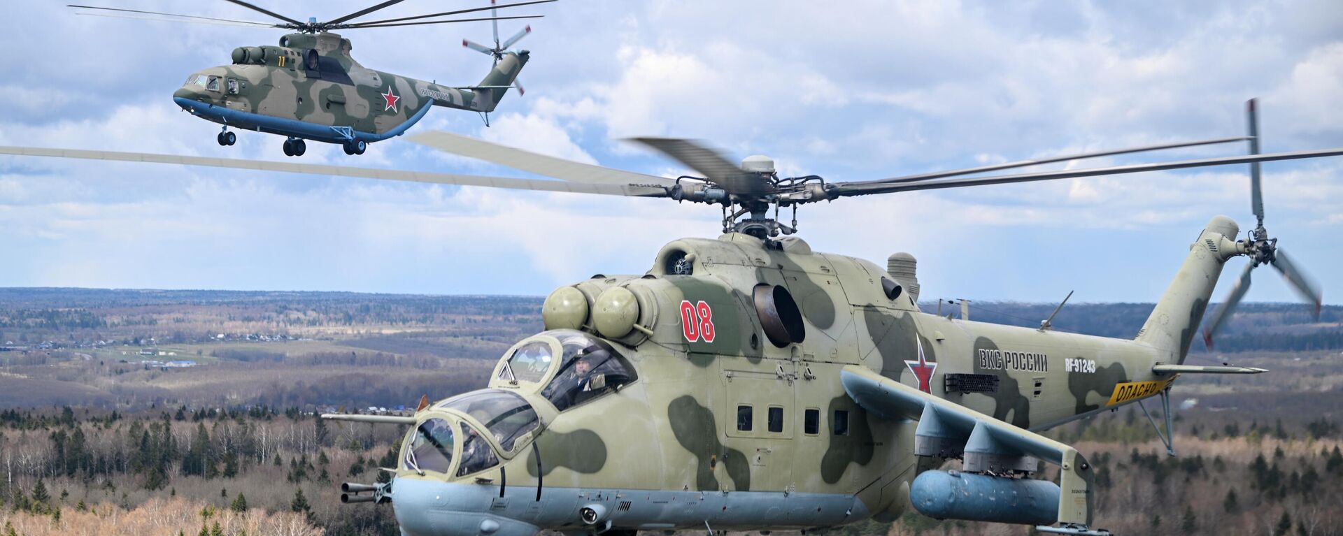 Тяжелый многоцелевой транспортный вертолет Ми-26 (на втором плане) и ударный вертолет Ми-24 летят на репетицию воздушной части парада Победы - Sputnik Latvija, 1920, 05.06.2022
