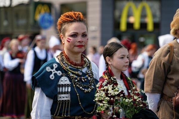 Колонна людей в национальных костюмах в Риге во время празднования Дня восстановления независимости Латвии. - Sputnik Латвия