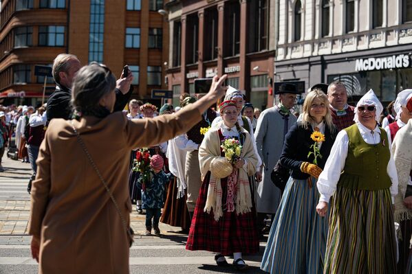 Колонна людей в национальных костюмах в Риге во время празднования Дня восстановления независимости Латвии. - Sputnik Латвия