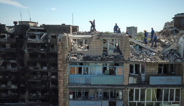 Сотрудники МЧС РФ разбирают завалы разрушенного дома на проспекте Мира в Мариуполе - Sputnik Латвия