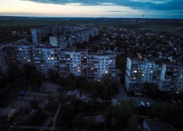 Свет в окнах жилых домах на окраине Мариуполя. - Sputnik Латвия
