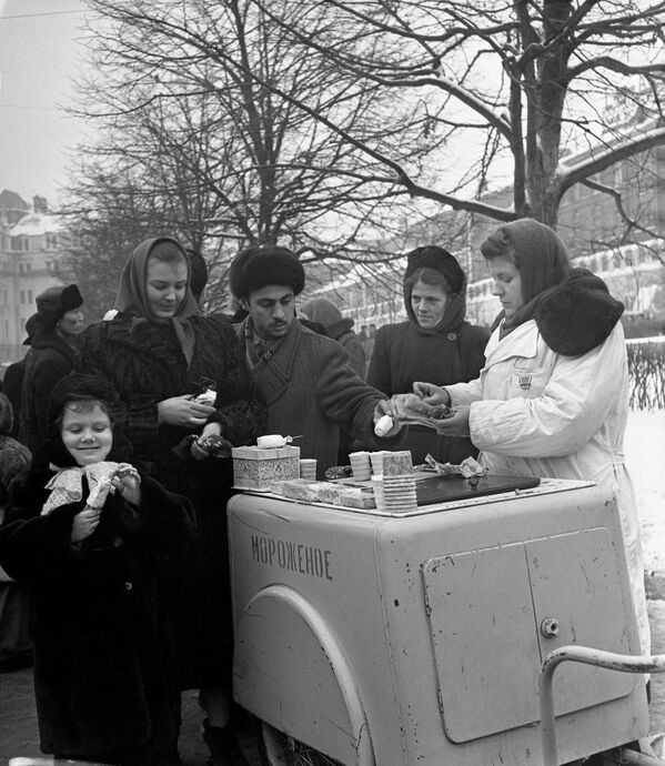 Несмотря на морозную погоду, жители города у стен Московского Кремля в Александровском саду с удовольствием пробуют мороженое 10 декабря 1955 года.  - Sputnik Латвия
