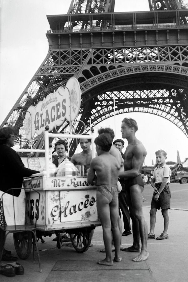 Молодые люди в купальниках покупают мороженое возле Эйфелевой башни, июль 1945 года.  - Sputnik Латвия