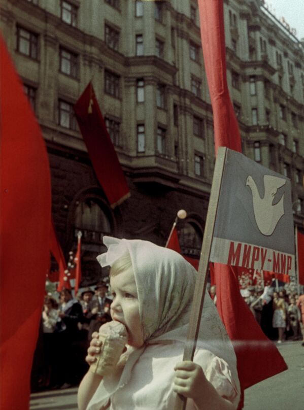 Юная участница первомайской демонстрации спасается от жары с помощью стаканчика мороженого, Москва, 1 мая 1964 года.  - Sputnik Латвия