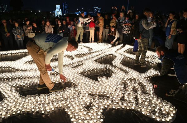 Свечи, зажженные участниками акции Свеча памяти у Музея Победы в Москве - Sputnik Латвия