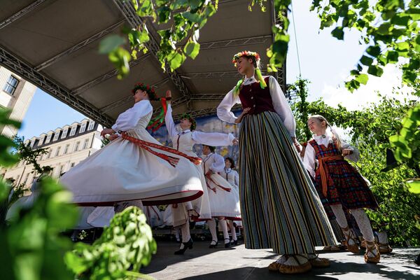 На сцене ярмарки на Домской площади выступают вокальные и танцевальные коллективы, хоры и оркестры. - Sputnik Латвия