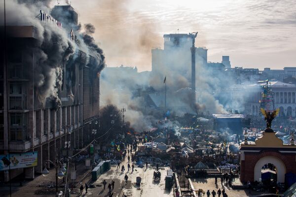 На фото: дым от пожаров и сторонники оппозиции на площади Независимости в Киеве - Sputnik Латвия