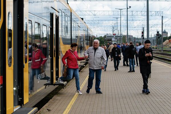 Пассажиры нового электропоезда выходят на платформу. - Sputnik Латвия