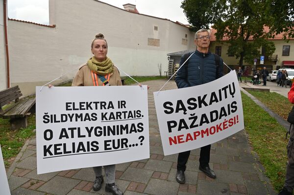 Участники акции протеста держат плакаты с надписями: &quot;Электричество и отопление в разы, а зарплата на несколько евро?&quot;, &quot;Обещаниями счета не оплатишь!&quot;. - Sputnik Латвия
