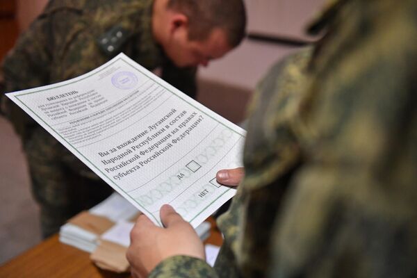 Военнослужащий Народной милиции ЛНР держит бюллетень на референдуме по вхождению ЛНР в состав России. - Sputnik Латвия