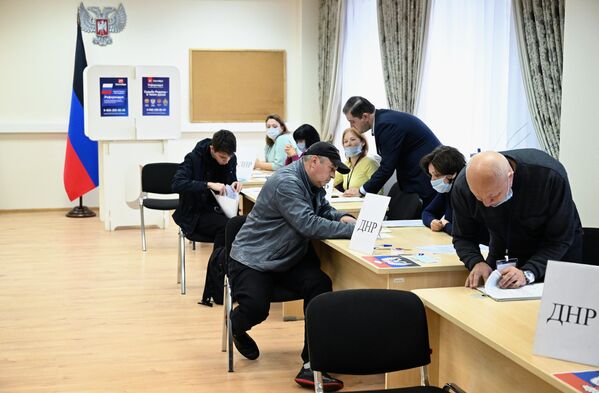 Мужчины голосуют на референдуме на избирательном участке в посольстве ДНР в Москве. - Sputnik Латвия