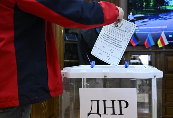 Мужчина голосует на референдуме на избирательном участке в посольстве ДНР в Москве. - Sputnik Латвия