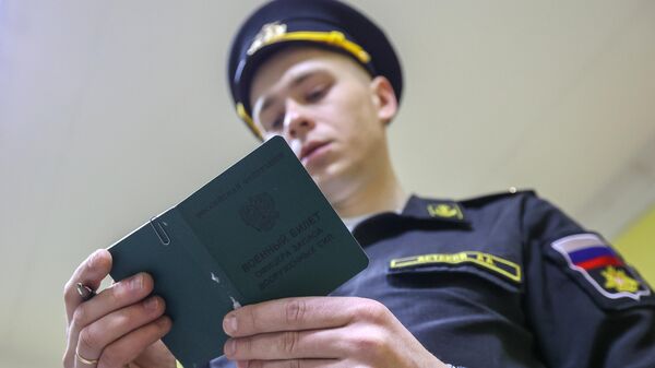 Сотрудник военного комиссариата в Мурманске изучает военный билет офицера запаса ВС - Sputnik Латвия