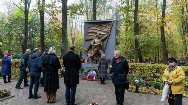 Жители Риги возлагают цветы к мемориалу советским воинам-освободителям на Покровском кладбище в Риге, 13 октября 2022 года - Sputnik Латвия