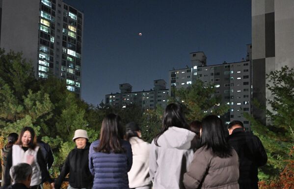 Люди наблюдают за кровавой луной во время полного лунного затмения недалеко от Сеула. - Sputnik Латвия