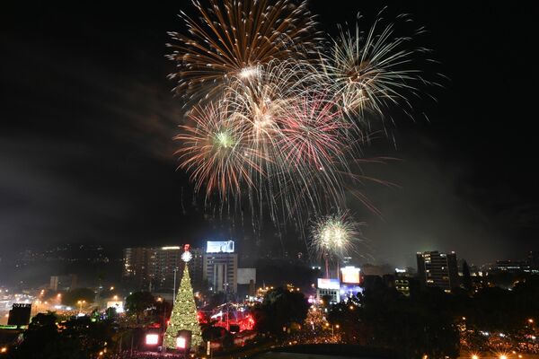 Небо освещают фейерверки на церемонии открытия рождественской елки высотой 35 метров на площади Эль-Обелиско в Гватемале. - Sputnik Латвия