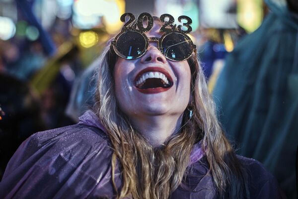 Девушка смеется, ожидая обратного отсчета до начала нового года на Таймс-сквер в Нью-Йорке 31 декабря 2022 года - Sputnik Латвия