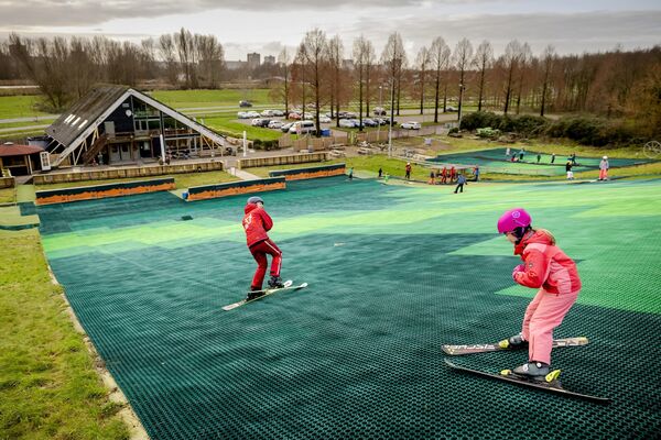 Дети на занятии по катанию на лыжах на искусственном склоне без снега, Бергшенхук, Нидерланды, 5 января 2023 года. - Sputnik Латвия
