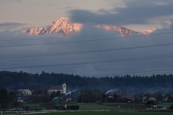 Альпийские вершины, которые обычно покрыты снегом, видны над деревней Накло, Словения, 4 января 2023 года. - Sputnik Латвия