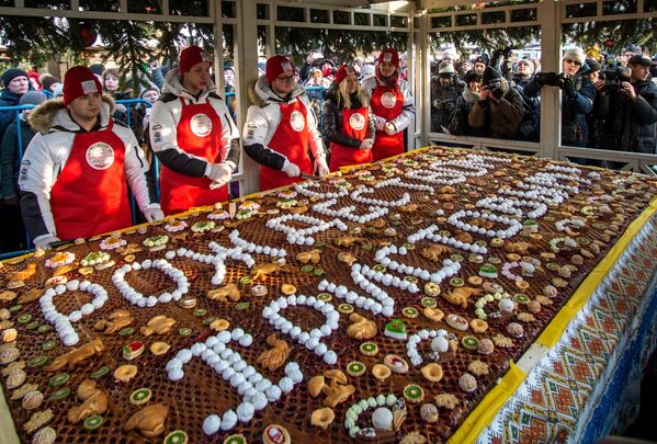 Раздача пирога весом в 100 кг, приготовленного в честь Рождества Красногорским хлебным комбинатом, на Манежной площади. - Sputnik Латвия