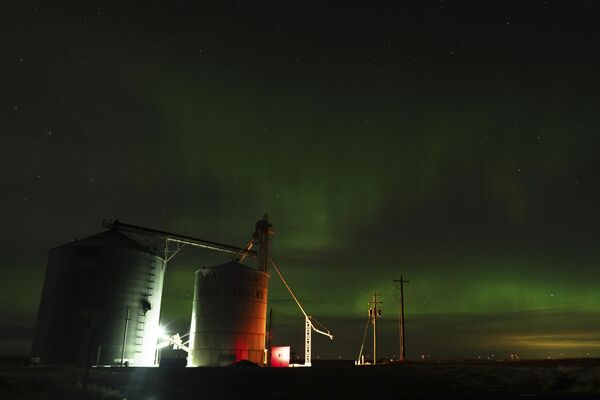 Северное сияние в ночном небе рядом с элеваторами недалеко от Ваштукны, штат Вашингтон. - Sputnik Латвия