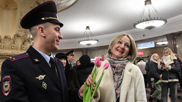 Сотрудник УВД на Московском метрополитене поздравляет женщину с наступающим 8 марта  - Sputnik Латвия