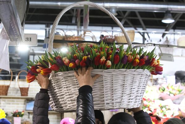 Мужчины несут корзину с цветами в преддверии Международного женского дня - Sputnik Латвия
