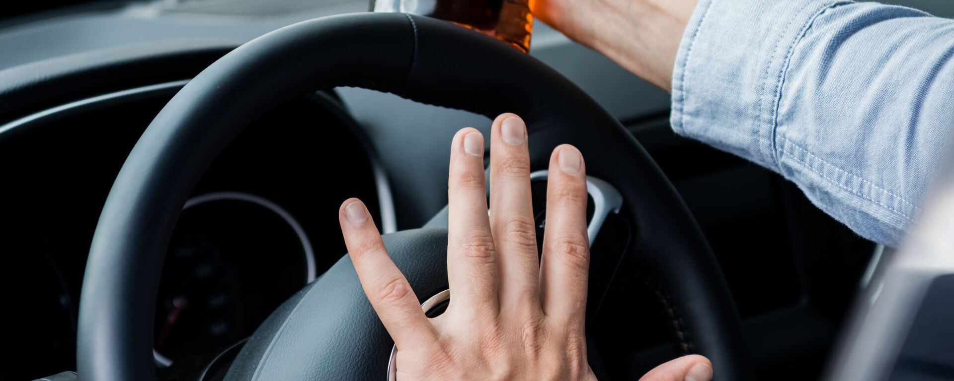 Водитель с бутылкой алкоголя за рулем, архивное фото - Sputnik Латвия, 1920, 09.11.2023