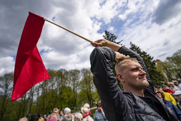 Участник митинга РСЛ с красным флагом - Sputnik Латвия