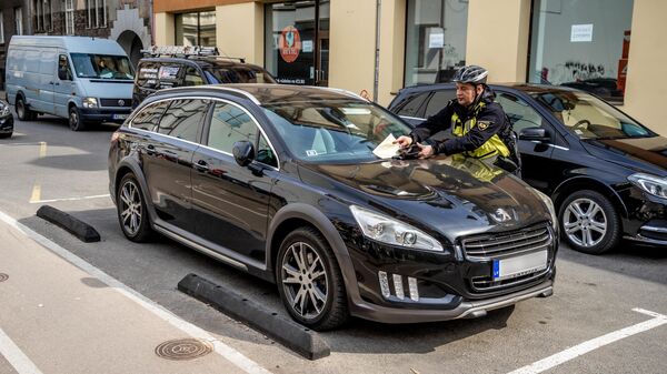 Сотрудник муниципальной полиции Риги выписывает штраф - Sputnik Латвия