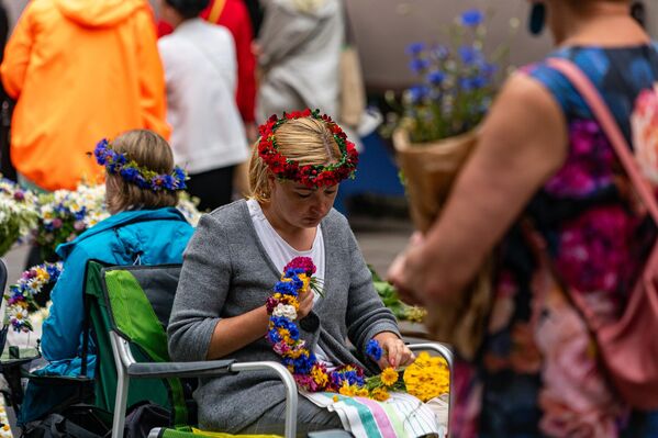 Девушка плетет венок накануне праздника Лиго на Домской площади в Риге. - Sputnik Латвия