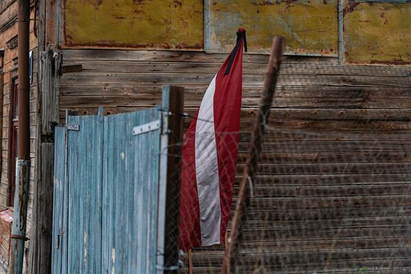 Флаг Латвии с траурной лентой на пути следования &quot;Марша живых&quot;. - Sputnik Латвия