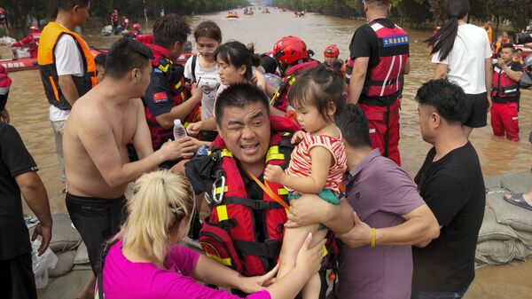 Спасатели на резиновых лодках эвакуируют оказавшихся в ловушке жителей через паводковые воды в Чжуочжоу в провинции Хэбэй на севере Китая - Sputnik Латвия