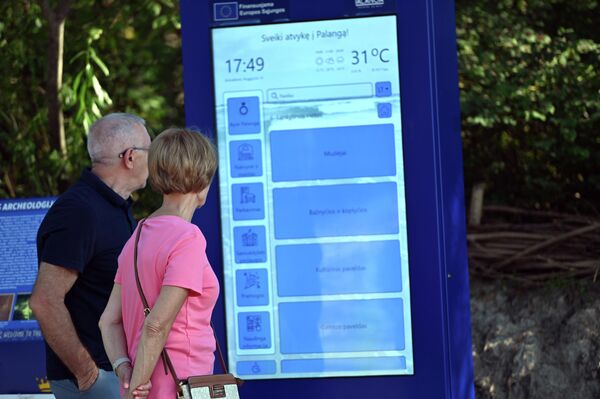 На фото: туристы стоят возле информационного стенда. - Sputnik Латвия