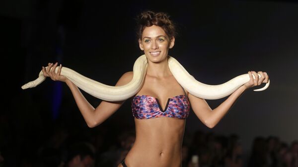 Модель с живой змеей во время показа Mercedes-Benz Fashion Week Swim в Майами-Бич, штат Флорида, США - Sputnik Латвия