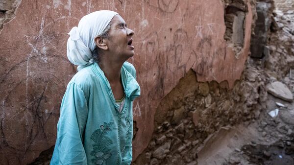 Женщина стоит перед своим поврежденным домом от землетрясения в старом городе Марракеша, Марокко - Sputnik Латвия