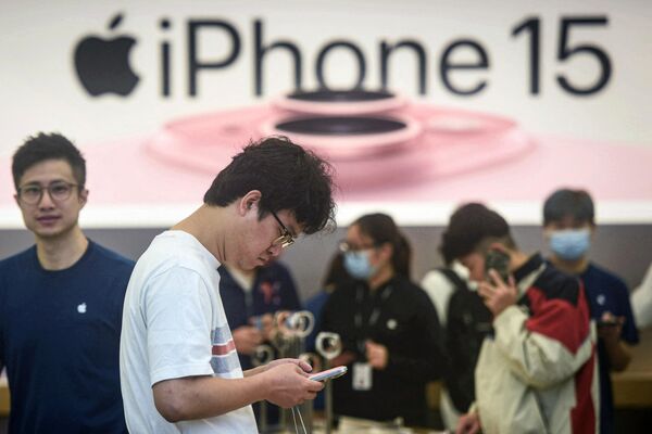 Мужчина тестирует поступивший в продажу iPhone 15 в магазине Apple в Ханчжоу - Sputnik Латвия