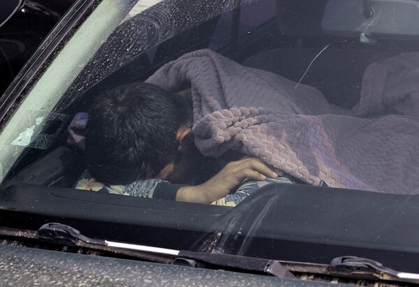 Беженец из Нагорного Карабаха спит в автомобиле возле гуманитарного центра в городе Горис - Sputnik Латвия