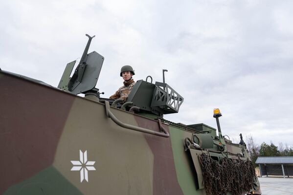 Латвийский военнослужащий в бронетранспортере Patria 6x6 Латвийский военнослужащий в бронетранспортере Patria 6x6 - Sputnik Латвия
