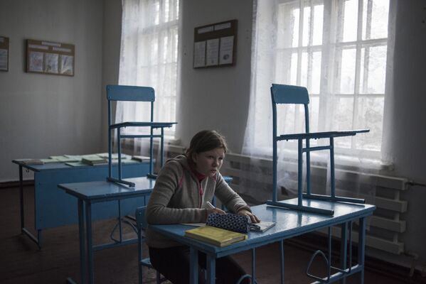 Девочка за партой в школе поселка Саханка Донецкой области - Sputnik Latvija