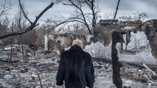 Женщина у разрушенного дома в поселке Саханка Донецкой области - Sputnik Latvija
