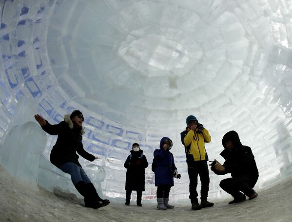 Люди фотографируются в иглу, построенного для зимних Олимпийских игр 2018 года в Пхенчхане, Южная Корея - Sputnik Латвия