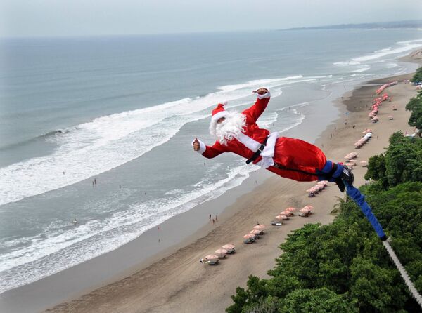 Мужчина в костюме Санта-Клауса во время банджи-джампинга на острове Бали  - Sputnik Латвия