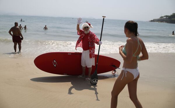 Мужчина в костюме Санта-Клауса на пляже в Бразилии - Sputnik Латвия