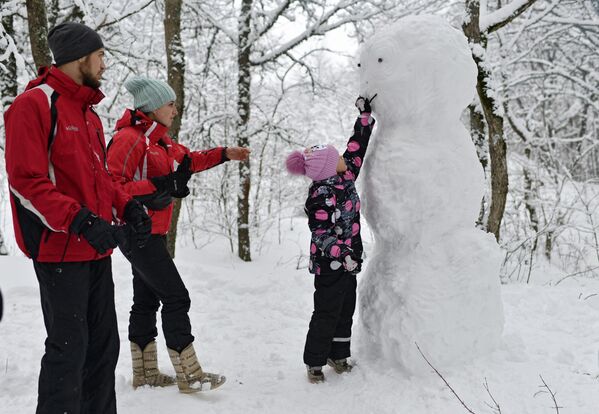 Семья с ребенком лепят снеговика во время отдыха на Ангарском перевале в Крыму - Sputnik Латвия