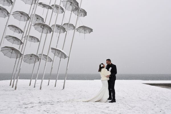 Молодожены на берегу моря во время снегопада в Греции  - Sputnik Латвия