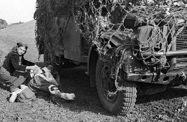 Румынская девушка перевязывает раненого советского солдата, 1944 год Румынская девушка перевязывает раненого советского солдата, 1944 год - Sputnik Латвия
